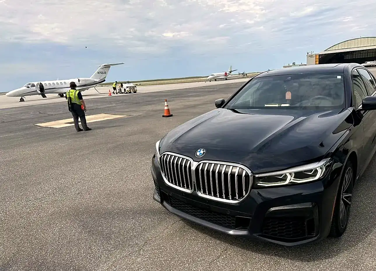 Royal Ride BMW 7 Series waiting beside a private jet on the tarmac